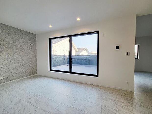 明るい光が差し込むリビングで窓からの景色も開放感があります。床と壁のデザインが調和してすっきりとした印象です。シンプルな空間がさまざまなインテリアにマッチします。