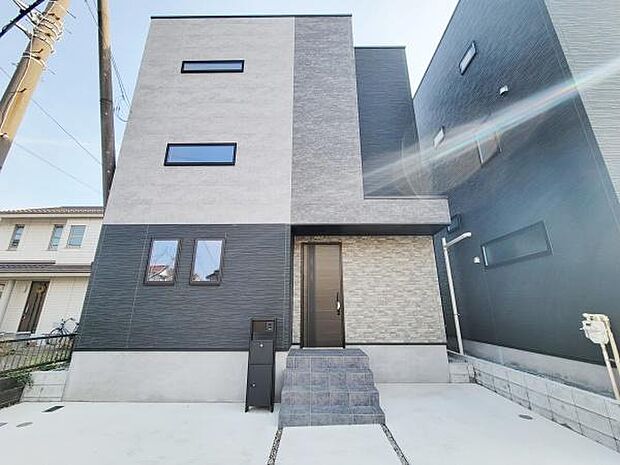 モダンな外観が特徴の住宅です。シンプルな配色でスタイリッシュな印象を与えます。玄関アプローチもすっきりとしています。駐車スペースも確保されています。デザイン性が際立つ建物です。