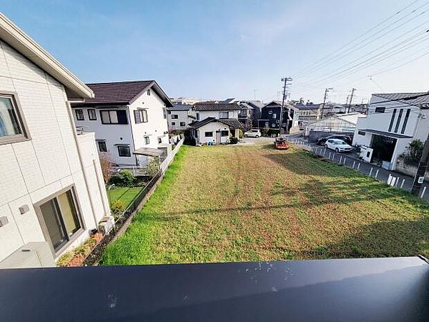 バルコニーからの現地からの眺望です。広々とした空き地が広がり敷地の開放感を感じられます。周囲は閑静な住宅街で落ち着いた印象です。陽当たりも良好で見通しの良い環境が魅力です。