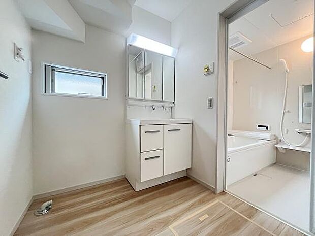 明るい色合いの洗面所は清潔感がありお手入れもしやすいスペースです。収納も充実しており使い勝手のよい仕様となっています。洗面台の鏡は大きめで見やすく窓からの採光も確保されています。