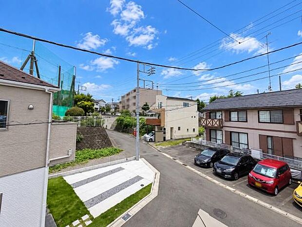 現地からの眺望写真です。周辺は住宅が並び道路も広めでゆとりが感じられます。周囲の建物との距離感もしっかり確保されています。空の広がりも感じられるため圧迫感がありません。