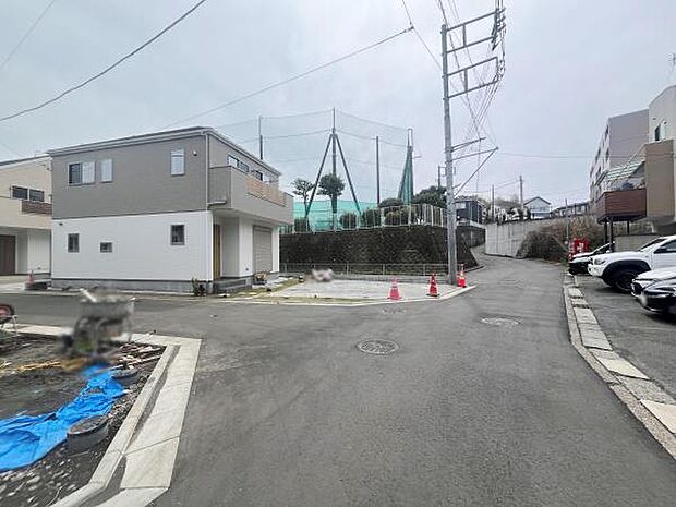現地の前面道路は広々とした印象で車の出入りもスムーズに行えます。周辺は整然とした街並みが広がっています。敷地までのアクセスも分かりやすく見通しのよい道が特徴的です。