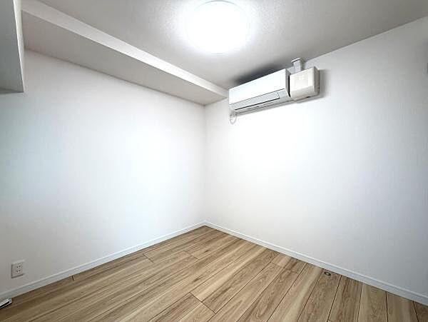 シンプルな内装でアレンジしやすい洋室です。明るい照明が部屋全体を照らし快適に過ごせます。木目調のフローリングが温もりを感じさせ落ち着いた雰囲気です。