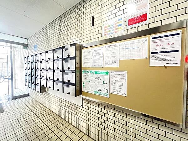 明るいエントランスには複数の郵便受けが並び利用しやすい環境が整っています。掲示板も設置されており管理体制を感じられます。清潔感のあるタイル張りの空間です。掲示物も見やすく配置されています。