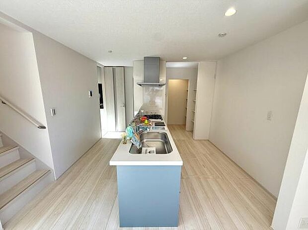 明るい色合いのフローリングが空間全体をすっきりとした印象にしています。アイランドタイプのキッチンで作業スペースにゆとりがあります。収納棚やカウンターなど使いやすさに配慮されています。