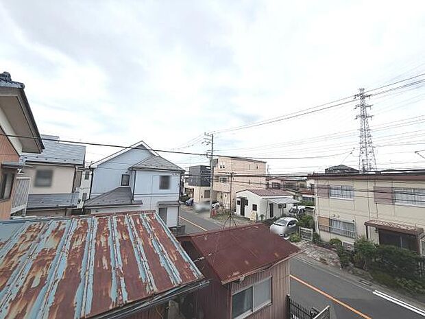 周囲に住宅が立ち並ぶ現地からの眺望です。道幅があり車の通行も確認できます。高い建物が少なく空が広く感じられます。生活利便施設が身近に揃っています。