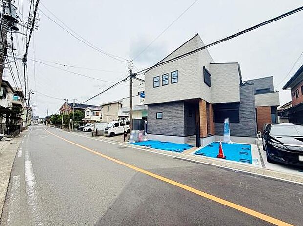 前面道路が広く見通しの良い環境です。周辺は住宅が並び落ち着いた印象を受けます。車の移動や駐車にもゆとりが感じられます。周囲には電柱や配線も整然と配置されています。建物周辺の舗装もしっかりされています。
