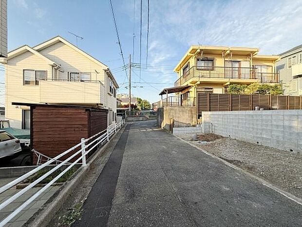 前面道路は幅があり車の通行もしやすい印象です。周辺には戸建てが並び落ち着いた街並みが感じられます。道路沿いに余裕があるため車や自転車の出入りも安心です。両側に住宅が立ち並び整った環境が特徴的です。