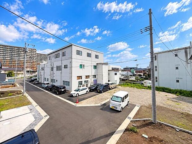 建物や道路が整然と配置されており周囲の環境がすっきりとしています。複数台分の駐車スペースが設けられており車の出入りにも余裕があります。新しい舗装道路が敷かれており全体的に清潔感のあるエリアです。