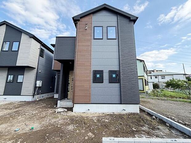 シンプルで洗練された外観が印象的です。異なる色味の外壁が調和し都会的な雰囲気を演出しています。玄関部分も奥行きがありアクセントとなっています。敷地も広く周囲との距離感も程よく保たれています。