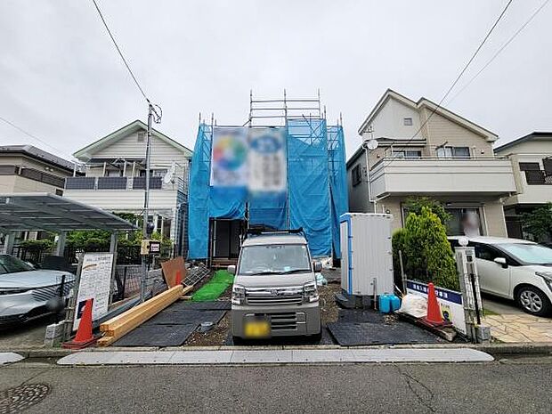 前面道路を含む現地写真です。車の出し入れがしやすい幅員となっています。周囲には整った街並みが広がっています。建築中の現地の様子がよく分かります。