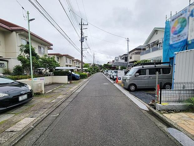 前面道路は幅員がしっかり確保されており車の出し入れもしやすい印象です。周辺には住宅が並び落ち着いた雰囲気が感じられます。