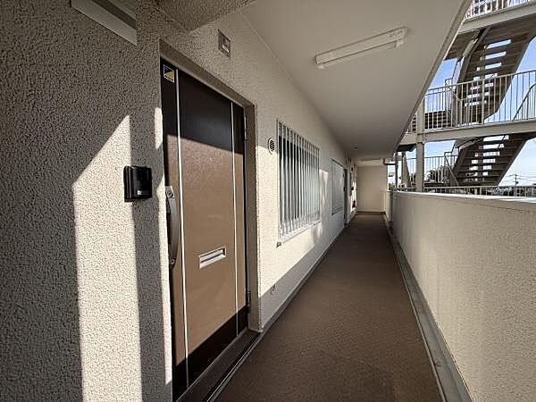 共用廊下は幅が広く移動がしやすい設計です。玄関前は視界が良好で開放感があります。外階段も近くフロアへのアクセスが便利です。採光があり明るい印象の共用スペースです。