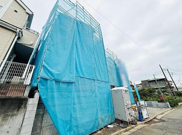 建築中の建物の様子が確認できます。周囲は閑静な住宅街で整った街並みが印象的です。道路沿いに位置し通行しやすい環境が特徴です。近隣にも住宅が建ち並んでいる点が安心感につながります。
