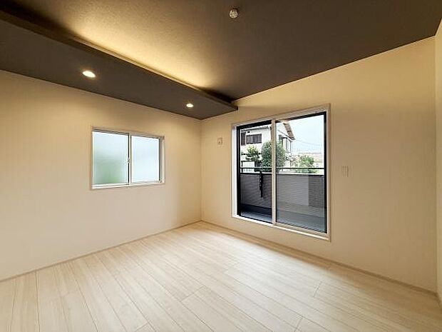 窓からの採光が心地よい寝室です。天井のダウンライトが落ち着いた雰囲気を演出しています。バルコニーに直接出られて便利です。ナチュラルなフローリングが空間を明るく見せます。