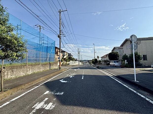 広々とした道路が印象的な街並みです。通り沿いには住宅が並んでおり落ち着いた雰囲気が感じられます。