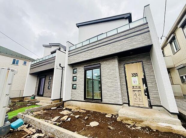 現代的な外観デザインが目を引く新築一戸建てです。グレーとホワイトのツートーンがスタイリッシュな印象を与えます。大きな窓が明るさを取り込み開放的な雰囲気を演出します。