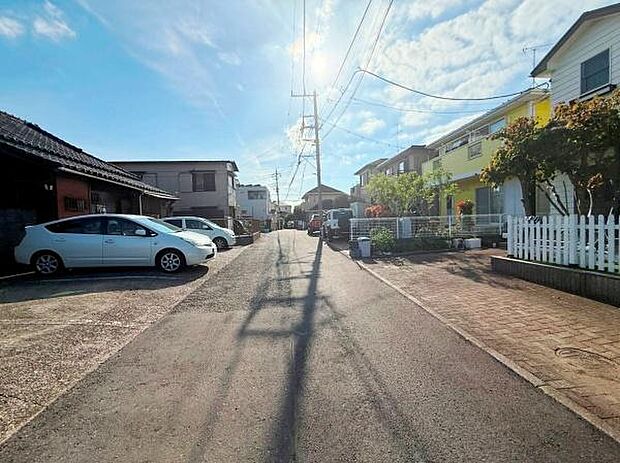 前面道路がしっかりと舗装されており周囲には住宅が整然と並んでいます。日当たりの良さが感じられる明るい通りです。周辺は車の通行もスムーズで道路幅にゆとりがあります。