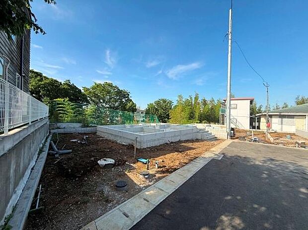 舗装された前面道路に面しており敷地までのアクセスがスムーズです。周辺には緑も多く開放感があります。道路幅も十分に確保されていて車の出入りも便利です。日当たりも良好な現地写真です。