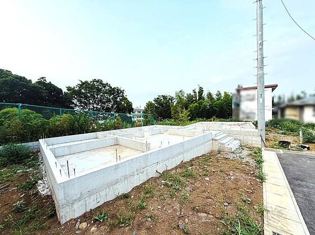 開放感のある現地写真です。前面道路が隣接しており敷地の全体像が見渡せます。周囲には緑も多くゆったりとした印象です。角地のためアクセスしやすい立地です。
