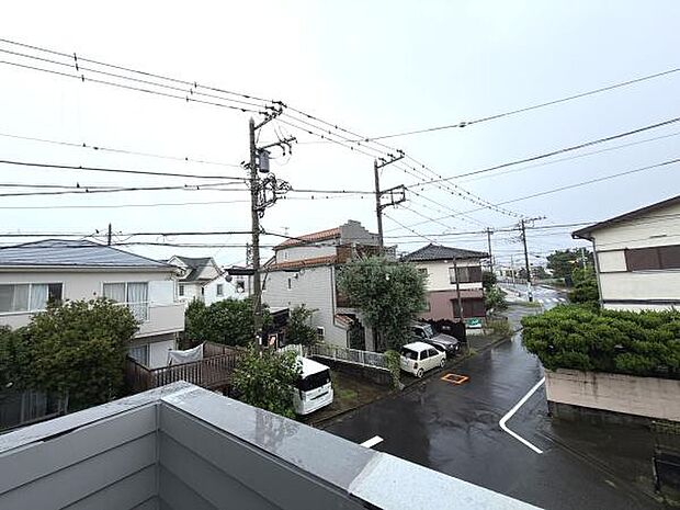 住宅街の落ち着いた雰囲気が感じられる現地からの眺望です。雨の日でも周囲の景色がしっかり確認できます。バルコニーから広がる街並みを楽しめます。周囲には緑も見受けられますので環境も魅力のひとつです。