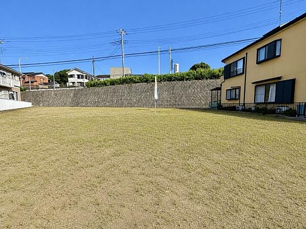 広々とした敷地が特徴の現地土地写真です。周囲は開放感のある環境が広がっています。建物の配置や設計にも自由度が感じられる土地です。道路からのアクセスも良好で使い勝手の良さが魅力です。