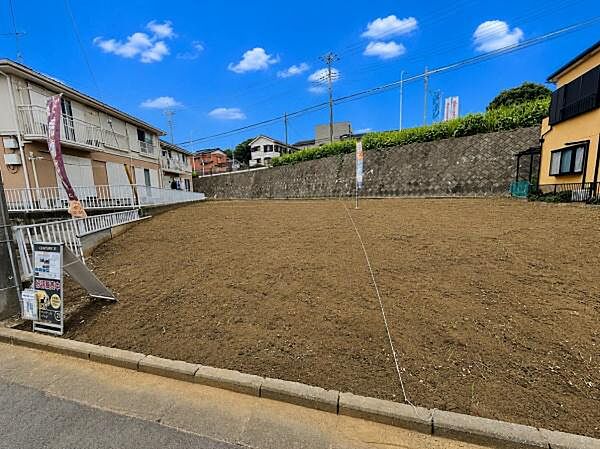 ゆったりとした敷地が広がる現地写真です。前面道路との接道も分かりやすく開放感のある雰囲気です。周囲には住宅が立ち並んでおり落ち着いた街並みが特徴です。整地された土の状態も良好です。