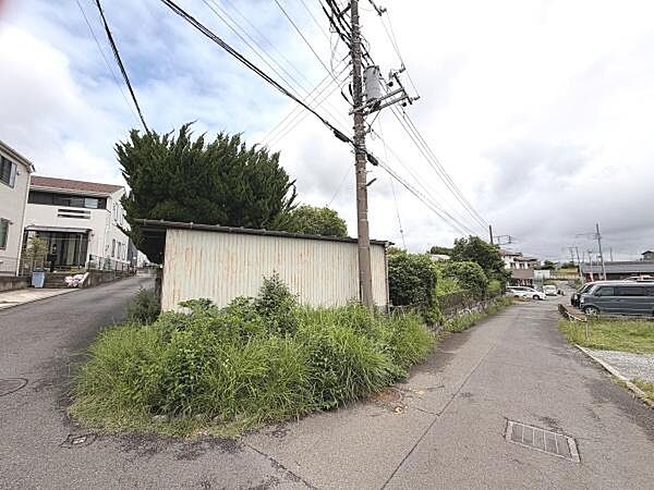 前面道路が広く車の出入りがしやすい配置です。周辺には住宅や緑も多く落ち着いた印象が伺えます。電柱や配線が整