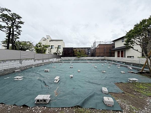 広々とした現地土地写真です。周囲は住宅が立ち並び静かな環境がうかがえます。整地済みで建築計画も立てやすい状態です。