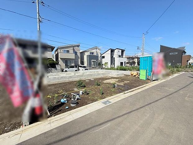 現地写真からは整備された前面道路と周囲の住宅がよくわかります。明るい空の下見通しの良い環境が印象的です。敷地は整地され利用計画も立てやすそうです。