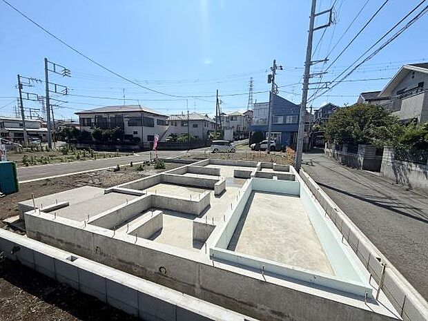 陽当たりの良い立地にある建築中の基礎部分です。周辺は閑静な住宅街でゆとりある道路に面しています。整然とした区画が特徴的です。建築プランに合わせた土台がしっかりと施工されています。