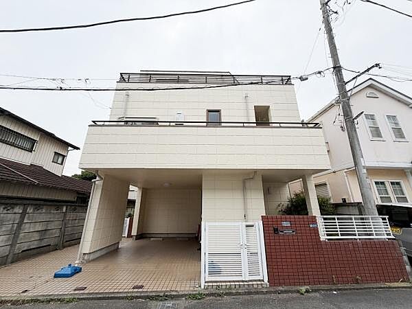 シンプルな外観が特徴的な建物です。敷地内に広々としたスペースがあります。前面道路もゆったりしており車の出入りもスムーズです。落ち着いた街並みに調和した現地写真となっています。