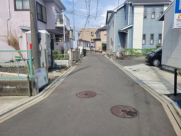 前面道路は舗装されており周辺は静かな住宅街となっています。車両の出入りがしやすく駐車スペースも確保されています。道路幅もゆとりがあり日常の利用に適しています。周囲には住宅が立ち並んでいます。