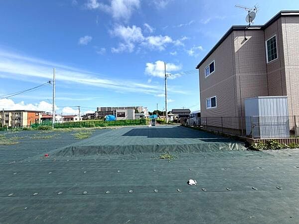 広々としたスペースが広がり周辺には住宅や車が整然と並んでいます。陽当たりの良さが感じられる明るい環境です。道路沿いに位置しており周囲の環境も落ち着いた印象です。