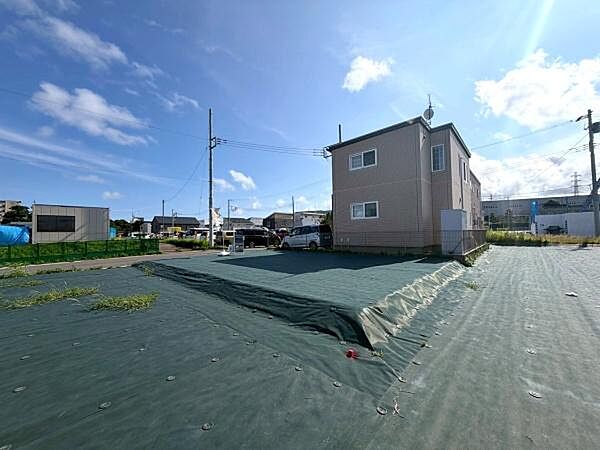 住宅や商業施設が点在するエリアに位置しています。広々としたスペースが確保されています。周辺道路も見通しが良く車の出入りがしやすい印象です。整地済みの土地で管理が行き届いた様子がわかります。