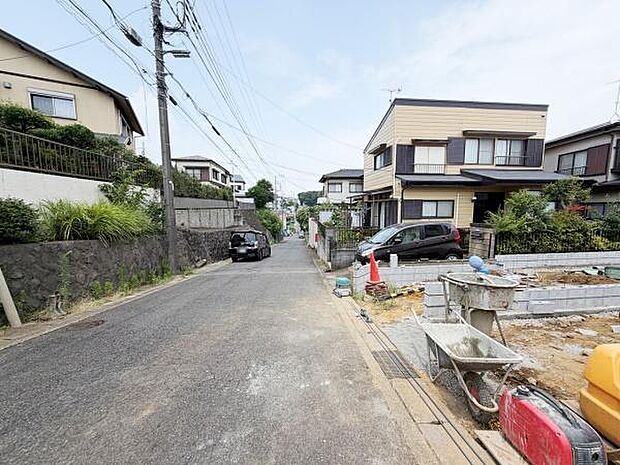 現地写真からは前面道路がしっかり整備されている様子がうかがえます。周囲には落ち着いた住宅が並び道路幅も十分に取られています。車の出入りもスムーズに行えそうです。