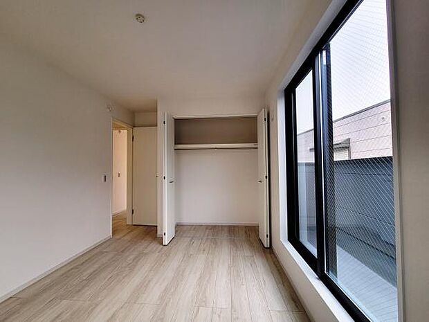 クローゼットが備わっており整理整頓がしやすい空間です。室内はシンプルでまとまりがあり明るい雰囲気が広がります。床材の色合いが落ち着いた印象を与えています。大きな窓からはしっかりと光が入ります。