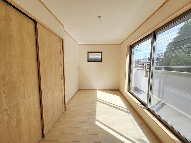 窓が大きく日差しが室内にしっかりと入ります。シンプルで使いやすい洋室となっています。ナチュラルな木目調の扉が空間に落ち着きを与えています。バルコニーへのアクセスも良好です。