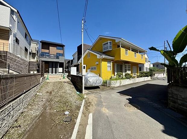 前面道路が広く駐車や車の出し入れにも余裕を感じられる環境です。周辺は住宅が整然と並び清潔感があります。道路面からの採光も良好で現地の明るい雰囲気が印象的です。美しい空模様も魅力を引き立てています。