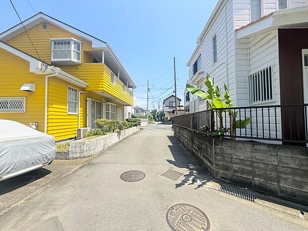 前面道路が広く駐車や車の出し入れにも余裕を感じられる環境です。周辺は住宅が整然と並び清潔感があります。道路面からの採光も良好で現地の明るい雰囲気が印象的です。美しい空模様も魅力を引き立てています。