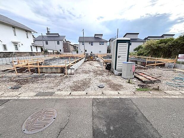 現地写真から周辺の落ち着いた住宅街の雰囲気が伝わります。前面道路は幅があり車の出し入れもスムーズに行えそうです。敷地の形状もわかりやすく日当たりも期待できます。工事の進行状況も一目で確認できます。