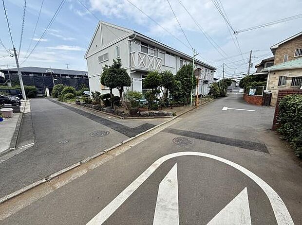 道路が交差する角地に位置し静かな住宅街の一角に建つ物件です。周囲は整った街並みが広がり落ち着いた環境が印象的です。敷地内には植栽も整えられており道幅が広く開放感があります。