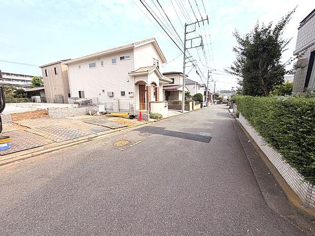 現地前面道路は幅員が広く車の通行もしやすい印象です。周囲の住宅も整然としており清潔感があります。歩道も整備されていて安心感があります。電柱や植栽など街並みが落ち着いた雰囲気です。