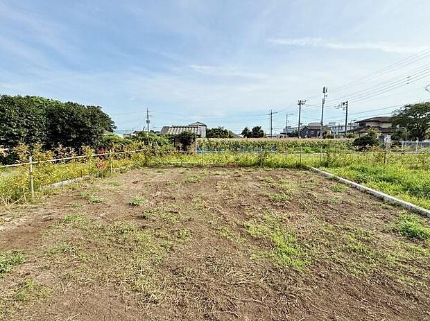 広々とした現地土地写真です。周囲には自然が多く視界が開けています。整地されており管理もしやすい状態です。道路にも面していて車の出入りも便利です。建築の検討に適した環境です。