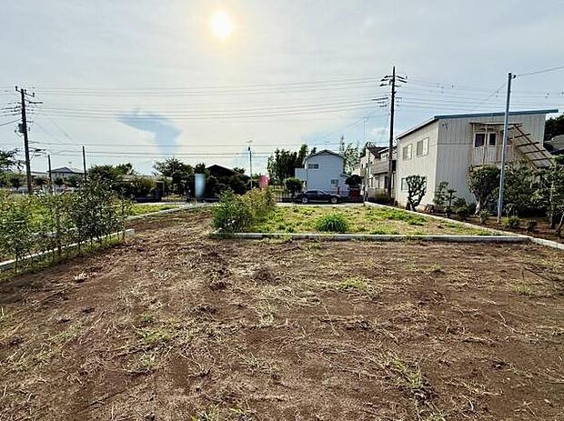 日当たりの良い環境で開放感のある現地土地写真です。周囲には住宅が点在し道路からのアクセスも便利です。敷地が広く多様な用途に対応できるポテンシャルがあります。建築プランに合わせやすい形状です。