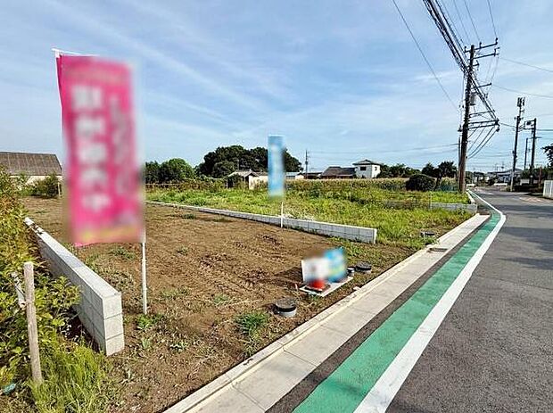 前面道路が広く車の出入りがしやすい現地写真です。周辺は開放感のある景観が広がっています。敷地の形状も確認できるためイメージがしやすいです。電柱や歩道が整備されている点も見受けられます。