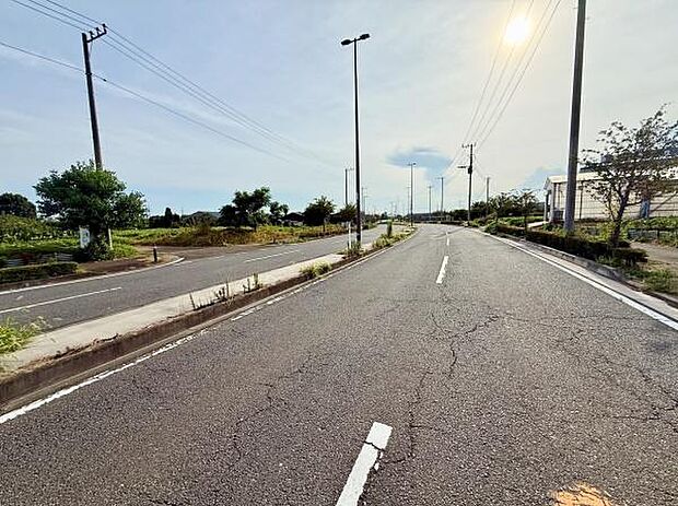 広々とした道路が印象的な場所です。周囲には緑が多く開放的な環境が広がっています。交通量が少なく落ち着いた雰囲気が感じられます。整備された歩道があり移動も便利です。