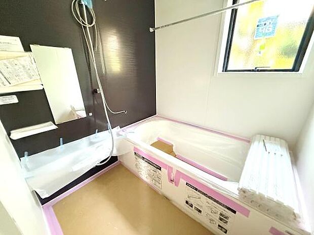 2号棟 窓からの採光があり明るい印象のバスルームです。壁面にダークトーンを採用しすっきりとしたデザインです。浴槽は広めの設計で快適にご利用いただけます。