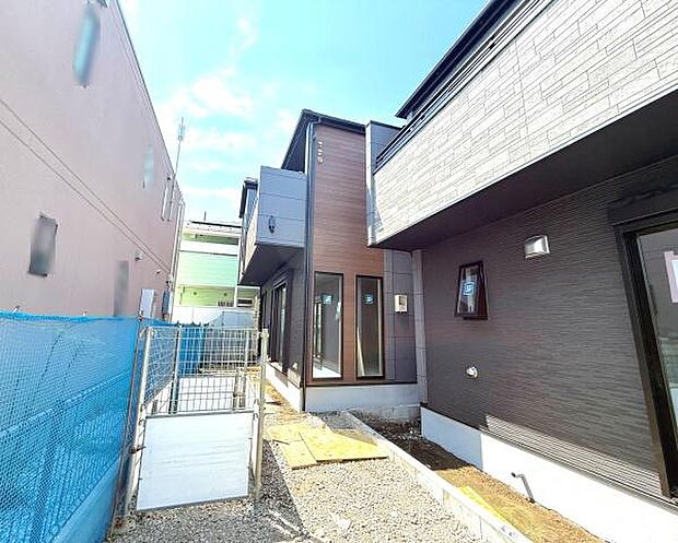 2号棟 外観はモダンなデザインで直線的なフォルムが印象的です。外壁の素材感が異なり個性的なアクセントになっています。明るい光が差し込む配置となっており通路も確保されています。