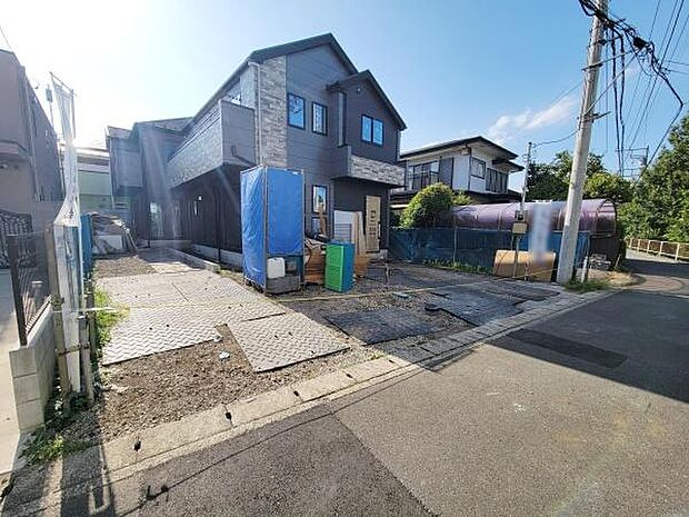 前面道路含む現地写真です。幅のある道路に面しており車の出し入れがしやすそうです。建物の外観もすっきりとした印象です。周囲には住宅が立ち並んでいます。